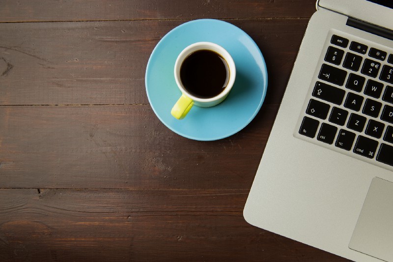 A person working on a laptop in a cafe, symbolizing a coding career change journey