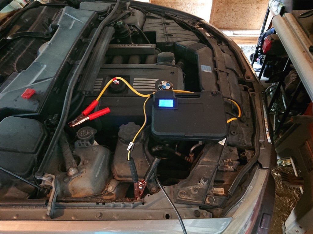 DIY car coding power supply connected to a car battery, showing voltage display