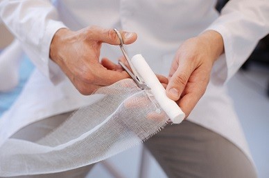 Medical professional examining a patient's wound, highlighting the need for specialized coding knowledge in wound care.