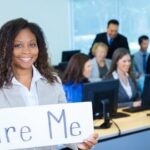 Diverse group of professionals at a medical coding career fair, engaging with virtual booths and exploring job opportunities.